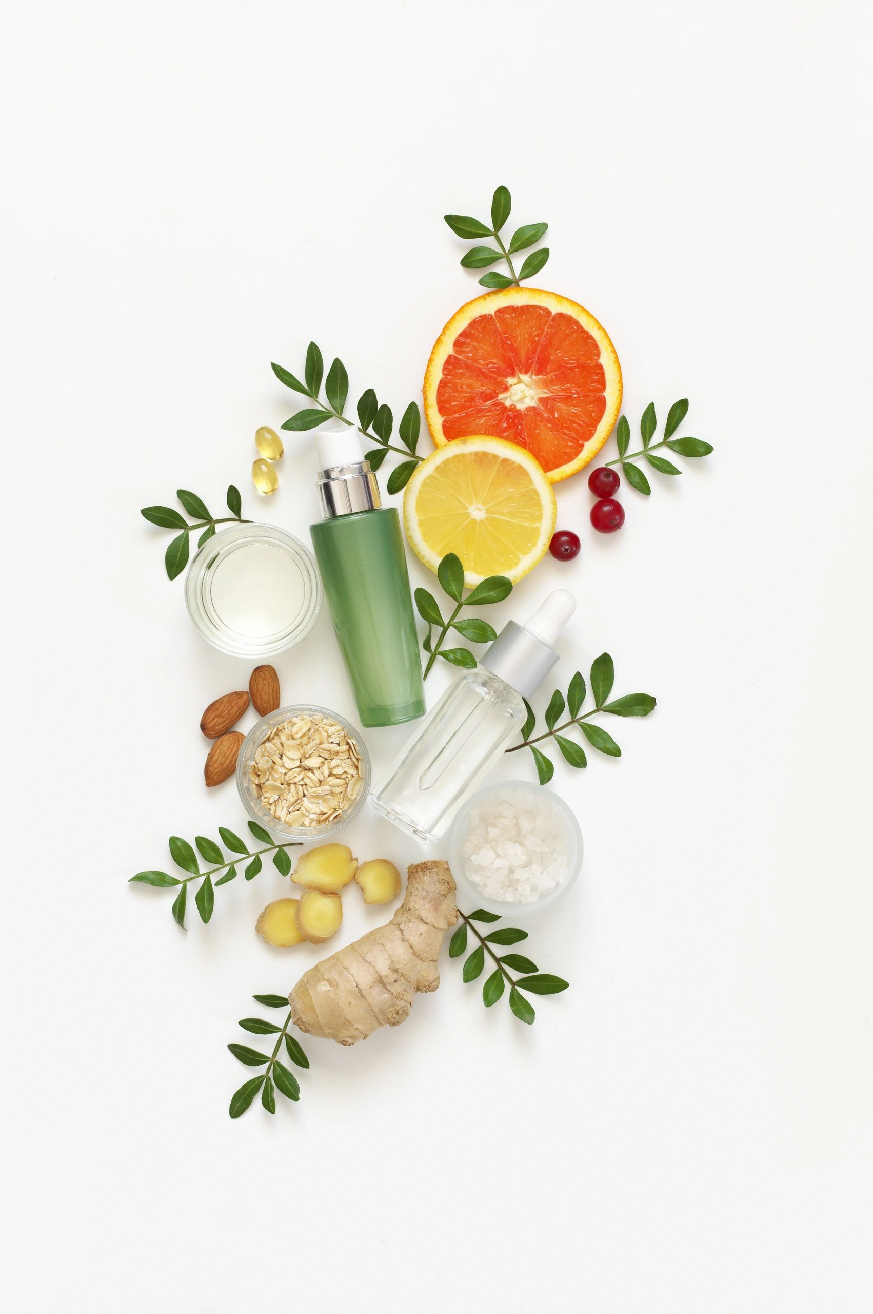 Natural skincare ingredients and leaves arranged on a light background