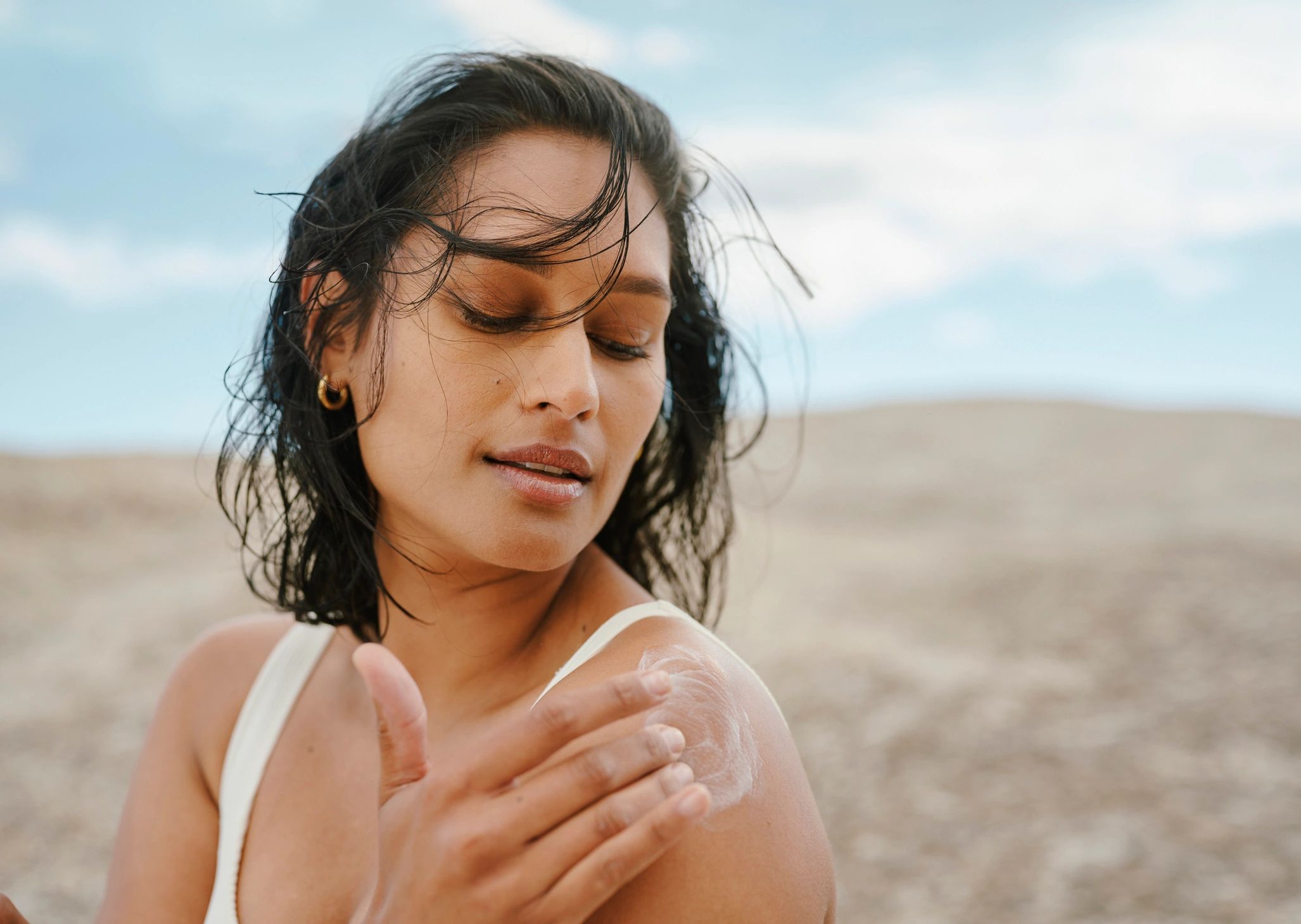 Woman applying a small amount of cream as part of a skincare ritual