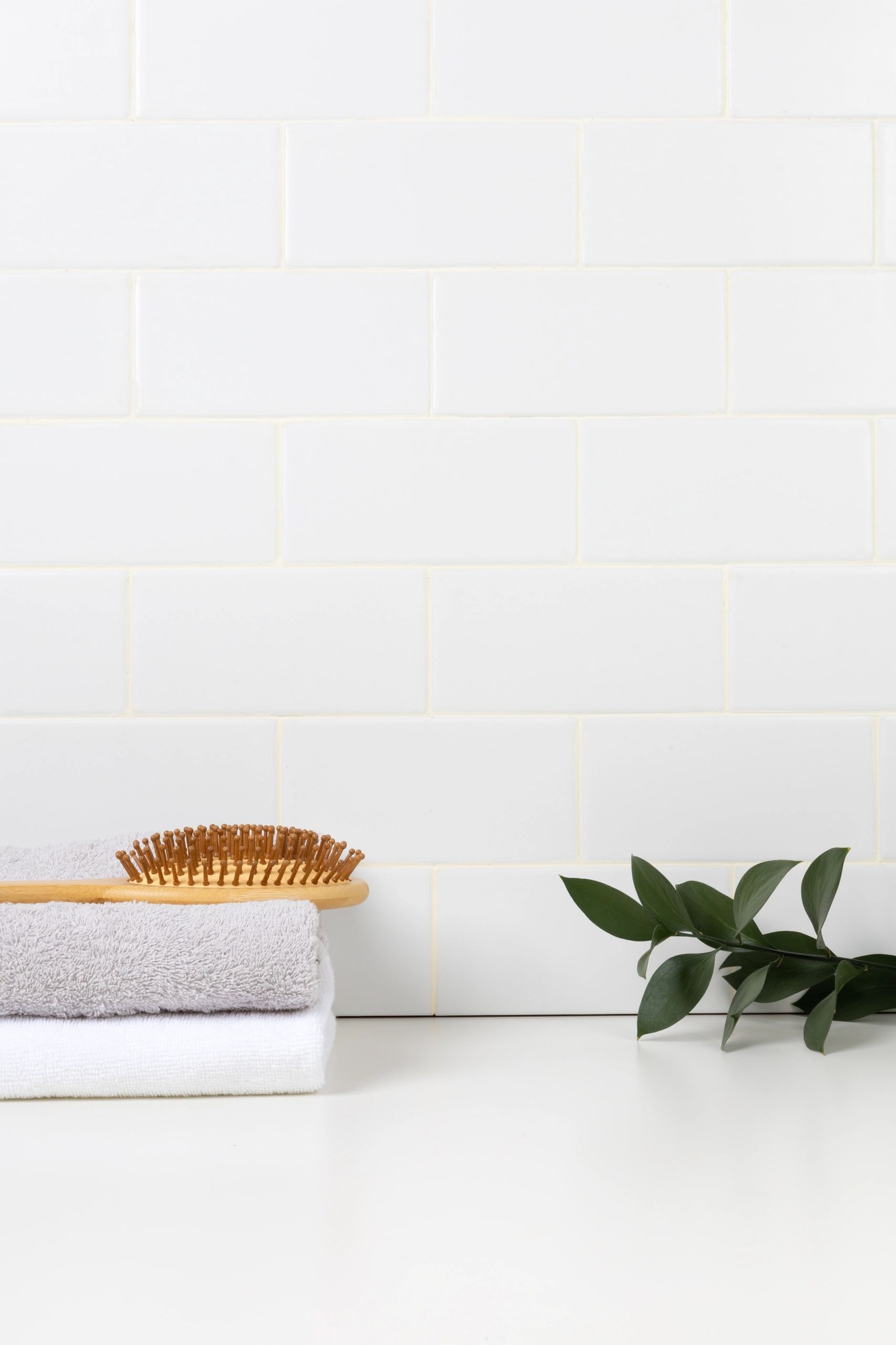 Minimal bathroom setting with greenery and towels for a calming skincare ritual